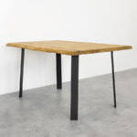 Drvena kvadratna ploča na četiri crne metalne noge za stol Simplex, visine 71 cm na sivim pločicama.