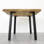 Drvena kvadratna ploča na četiri metalne crne noge za stol i stolić Simplex visine 71 cm na podlozi od sivih pločica.